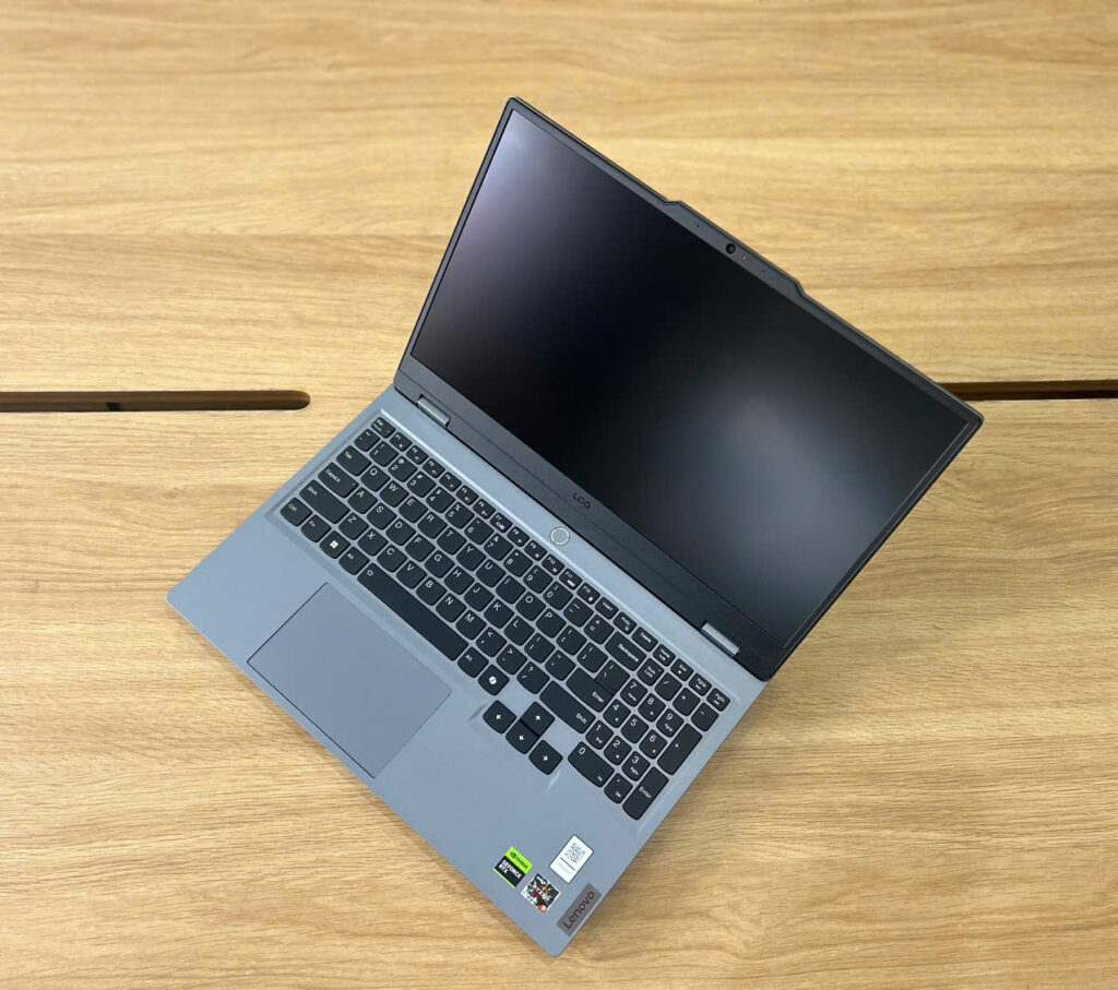 Laptop on wooden table, screen off.